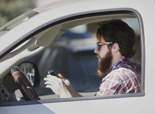 A file photo of a man texting at the wheel.