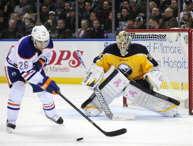 Edmonton Oilers center Mark Arcobello (26) tries to deflect the puck against Buffalo Sabres goaltender Michal Neuvirth (34), of the Czech Republic, during the second period of an NHL hockey game Friday, Nov. 7, 2014, in Buffalo, N.Y. 
