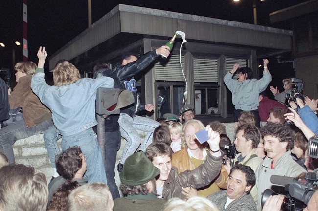 In this Nov. 10, 1989, file photo, East and West Berliners mingle as they celebrate in front of a control station on East Berlin territory, during the opening of the borders to the West following the announcement by the East German government that the border to the West would be open. 
