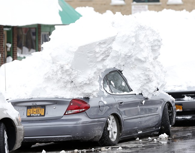 A car is weighed down by heavy snow in the south Buffalo area on Saturday, Nov. 22, 2014, in Buffalo, N.Y. Western New York continues to dig out from the heavy snow dropped by this week by lake-effect snowstorms. (AP Photo/Mike Groll).
