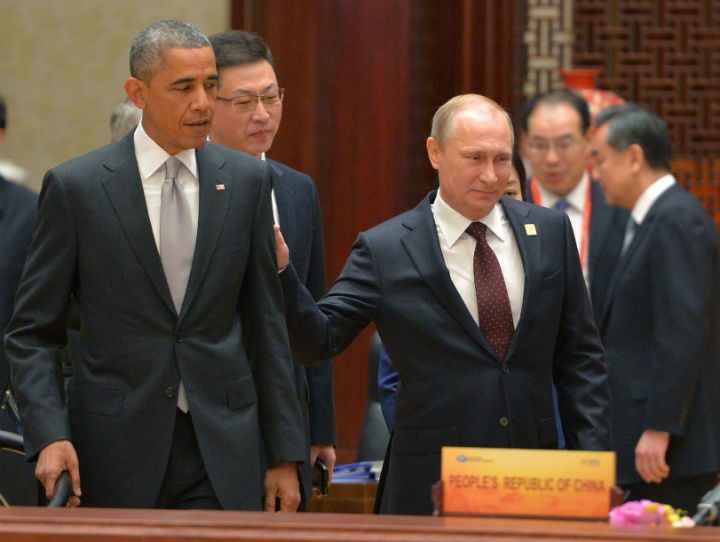 Russian President Vladimir Putin, right, passes by US President Barack Obama at the Asia-Pacific Economic Cooperation (APEC) Summit, Tuesday, Nov. 11, 2014 in Beijing.  The two leaders will both attend the G20 Summit in Brisbane, Australia this weekend. 