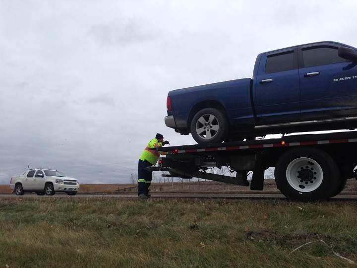 John Tennent of Crane Towing in Winnipeg works beside the Perimeter Highway on Tuesday.