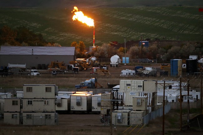 FILE - In this June 9, 2014 file photo, the burn off flame of natural gas lights up the night sky in Williston, N.D. North Dakota's booming oil production has led to an unmanageable increase in the state's output of natural gas, which is a byproduct of oil production. About a third of the state's natural gas production is now burned off and wasted because the pipeline network needed to transport the fuel to processing plants is not fully developed. (AP Photo/Charles Rex Arbogast, File).