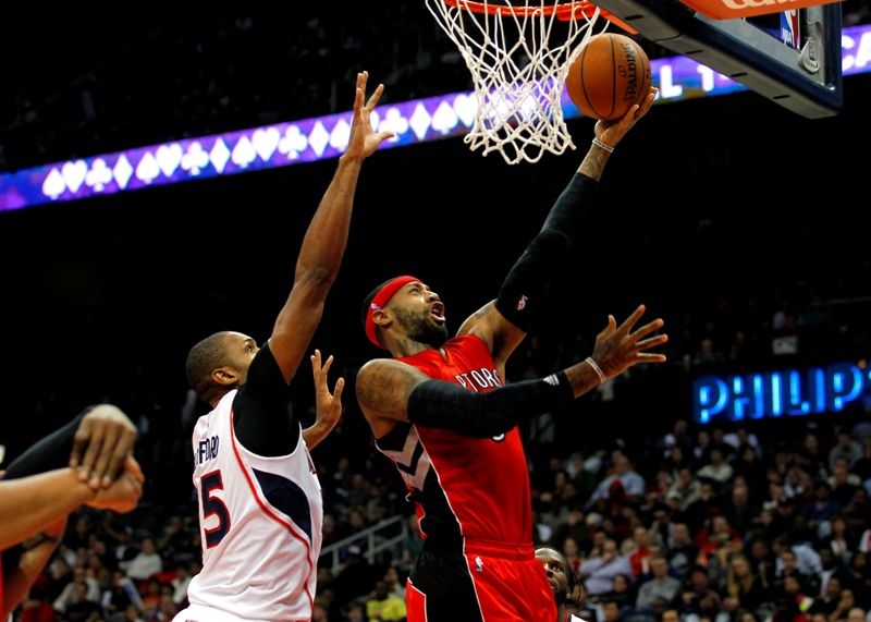 Toronto Raptors forward James Johnson (3) goes up for the shot over Atlanta Hawks center Al Horford (15) in the fourth period in an NBA basketball game in Atlanta, Wednesday, Nov. 26, 2014.