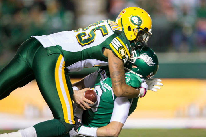 Seth Doege #9 of the Saskatchewan Roughriders is sacked by Dexter McCoil #45 of the Edmonton Eskimos in a game between the Edmonton Eskimos and Saskatchewan Roughriders in week 20 of the 2014 CFL season at Mosaic Stadium on November 08, 2014 in Regina.