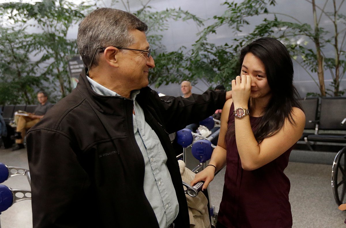 Jennifer Phan, right, is greeted by Joe Randazzo, the father of Liana Randazzo, after she arrived at San Francisco International Airport in San Francisco, Tuesday, Nov. 11, 2014. Phan and Liana Randazzo were two of the four U.S. students who traveled to Russia for a leadership conference and had their trip cut short and ordered home after Russian authorities said they had the wrong visas.