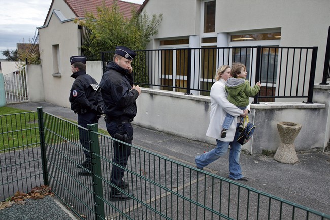 Police officers stand next to a school in Montevrain, east of Paris, Friday Nov. 14, 2014. Scores of police patrolled a small town west of the French capital on Thursday night after a 'big cat' eluded a massive search and remained on the prowl in the region near Disneyland Paris.