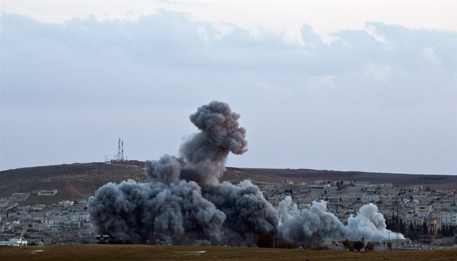 Smoke rises above the Syrian city of Kobani after an airstrike by the US led coalition, seen from a hilltop on the outskirts of Suruc, near the Turkey-Syria border Sunday, Nov. 2, 2014. 