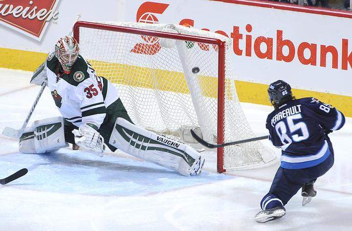 Mathieu Perreault of the Winnipeg Jets shoots the puck over the pad of goaltender Darcy Kuemper of the Minnesota Wild for a second period goal on Monday at the MTS Centre in Winnipeg.
