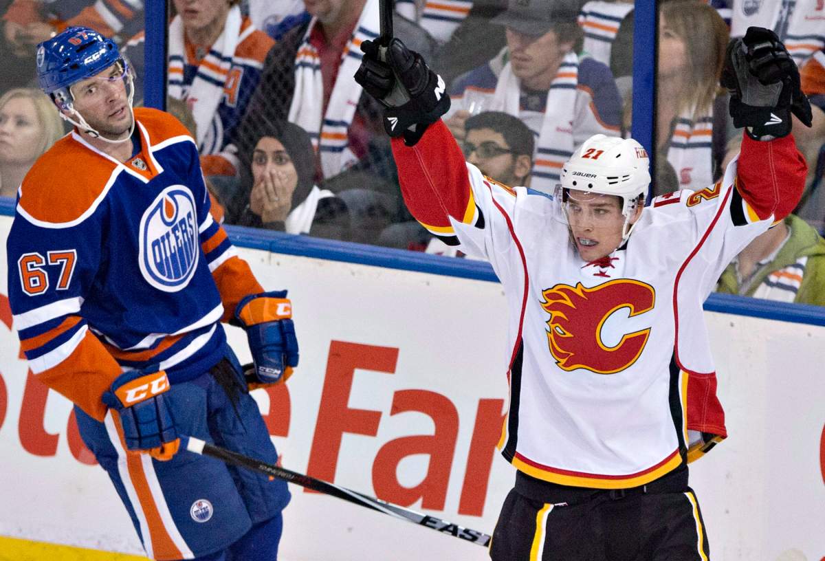 Calgary Flames’ Mason Raymond (21) celebrates a goal as Edmonton Oilers’ Benoit Pouliot (67) looks on.