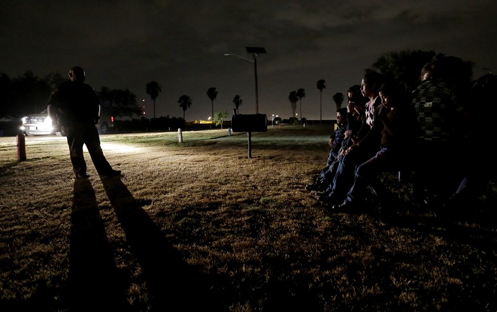 In this June 25, 2014, file photo, a group of immigrants from Honduras and El Salvador, who crossed the U.S.-Mexico border illegally, are stopped in Granjeno, Texas. The Homeland Security Department is experimenting with a new way to track immigrant families caught crossing into the U.S. illegally then released: GPS-enabled ankle bracelets.