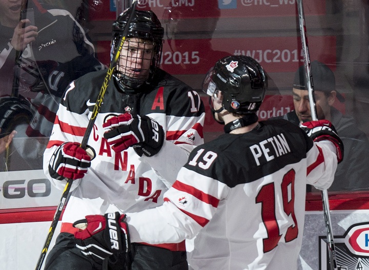 Team Canada's Connor McDavid, left, celebrates his goal against Team Germany with teammate Nic Petan during first period preliminary round hockey action at the IIHF World Junior Championship Saturday, December 27, 2014 in Montreal. 