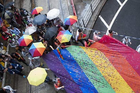 People march in Causeway Bay district during the Gay Pride Parade in Hong Kong on November 8 2014.  The atmosphere was jovial as nearly two thousand people, some wrapped in rainbow-coloured flags and some dressed in drag took to the streets in Hong Kong's Gay Pride parade .