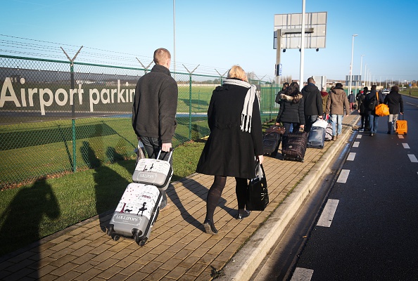 Travellers walk outside 'Brussels South Airport' in Charleroi, during a strike in the Hainaut province, on November 24, 2014.