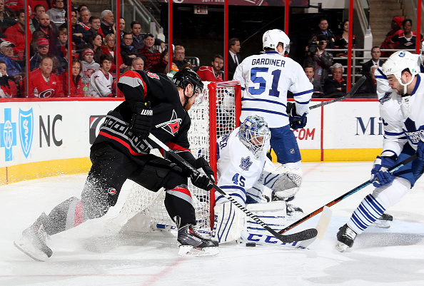  Jonathan Bernier#45 of the Toronto Maple Leafs keeps his stick on the ice to deny a scoring attempt by Brad Malone #24 of the Carolina Hurricanes during their NHL game at PNC Arena on December 18, 2014 in Raleigh, North Carolina.  