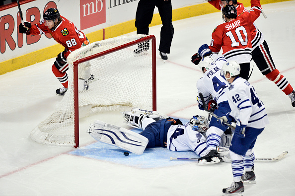 Patrick Kane #88 of the Chicago Blackhawks (L) scores on goaltender James Reimer #34 of the Toronto Maple Leafs during the third period at the United Center on December 21, 2014 in Chicago, Illinois. The Blackhawks defeated the Maple Leafs 4-0. 