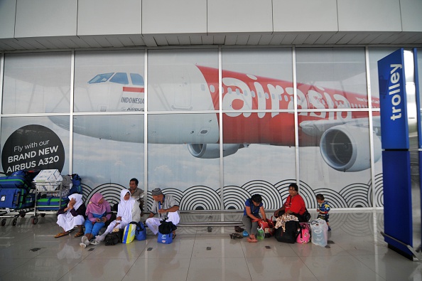Peoples waiting for their family in front of a Air Asia billboard at the arrival terminal at Soekarno Hatta International Airport near Jakarta, on December 29. Indonesia get help a aircraft and ship from Malaysia, Singapore and Australia to find the missing Air Asia near Borneo while flying from Surabaya to Singapore with 162 passengers on board.