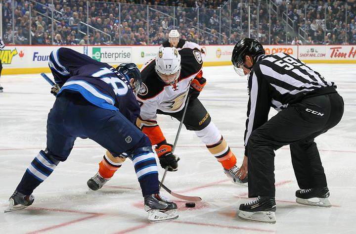 Bryan Little of the Winnipeg Jets takes a first period faceoff against Ryan Kesler of the Anaheim Ducks.