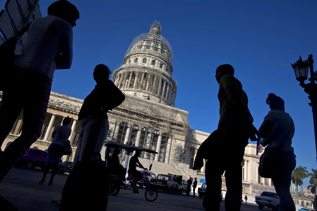 People line up to take the bus outside the Capitolio in Havana, Cuba, Thursday, Dec. 18, 2014. 