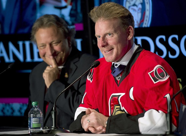 Ottawa Senators owner Eugene Melnyk looks on as Daniel Alfredsson responds to a question during a news conference after signing a one day contract Thursday December 4, 2014 in Ottawa.