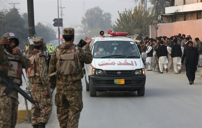 Ambulances carry injured people outside a school attacked by the Taliban in Peshawar, Pakistan, Tuesday, Dec. 16, 2014. 
