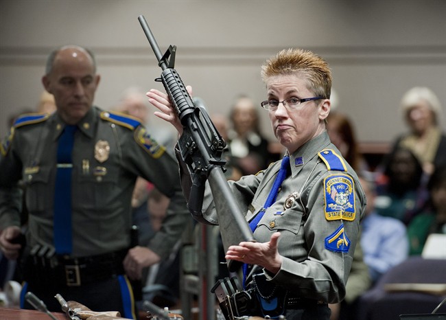 In this Jan. 28, 2013, file photo, firearms training unit Detective Barbara J. Mattson, of the Connecticut State Police, holds up a Bushmaster AR-15 rifle, the same make and model of gun used by Adam Lanza in the Sandy Hook School shooting.