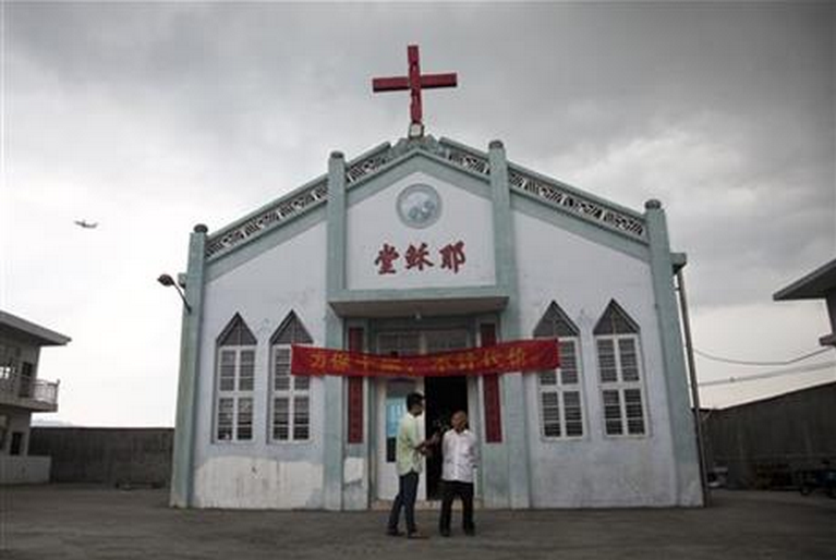 In this photo taken July 15, 2014, Pastor Tao Chongyin, left, speaks with church member Fan Liang'an in front of the Wuxi Christian Church.