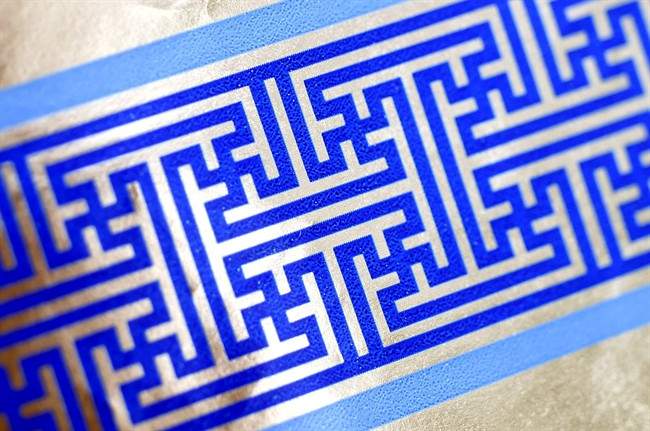 Cheryl Shapiro displays the Hanukkah gift wrap with a swastika-like pattern she found at Walgreens in Northridge, Calif., Monday, Dec. 8, 2014. 