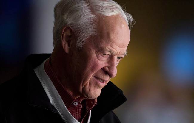 Hockey great Gordie Howe watches the Vancouver Canucks and San Jose Sharks play during an NHL hockey game in Vancouver, B.C., on November 14, 2013.
