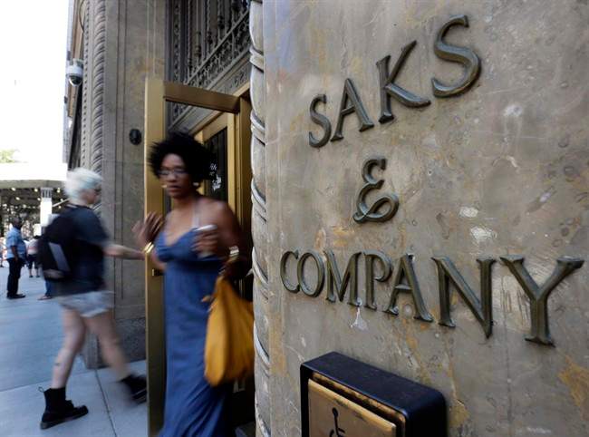 Shoppers use a Fifth Avenue entrance to Saks, in New York, Monday, July 29, 2013. Saks Inc. agreed to sell itself to Hudson's Bay Co., the Canadian parent of upscale retailer Lord & Taylor, for about $2.4 billion in a deal that will bring luxury to more North American locales. 