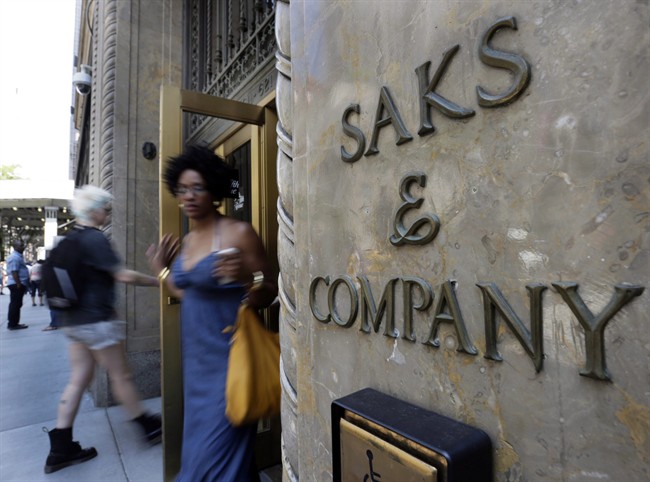 Shoppers use a Fifth Avenue entrance to Saks, in New York, Monday, July 29, 2013. Saks Inc. agreed to sell itself to Hudson's Bay Co., the Canadian parent of upscale retailer Lord & Taylor, for about $2.4 billion in a deal that will bring luxury to more North American locales. 