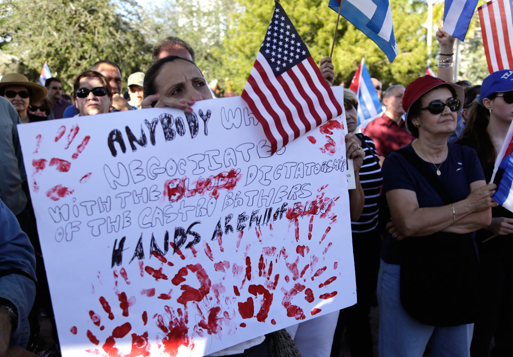 Sonia San Martin holds a sign during a protest in the Little Havana neighborhood of Miami on Saturday, Dec, 20, 2014 against President Barack Obama's plan to normalize relations with Cuba. 