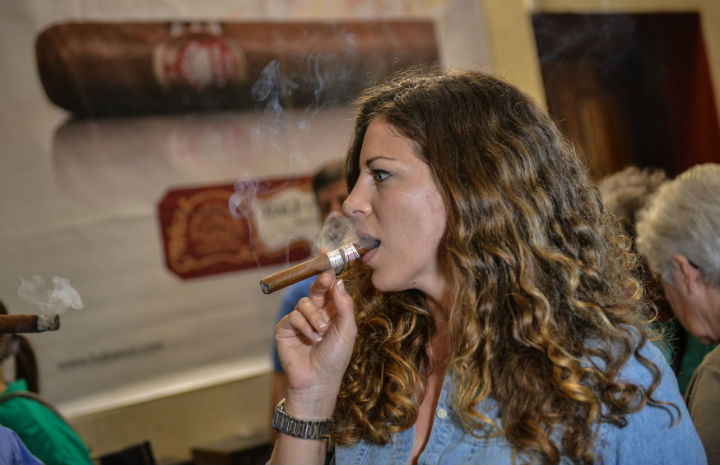 A tourist smokes a Cuban cigar, on February 27, 2014 during a guided visit to the H. Upmann cigar factory in Havana.