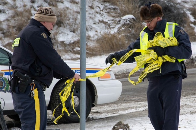 RCMP officers take down police tape in Kamloops, B.C. on Wednesday Dec. 3, 2014.