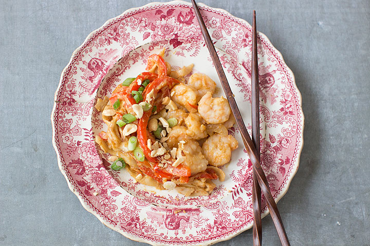 This photo shows fried udon noodles with shrimp and spicy sauce. Fried udon noodles with red peppers and shrimp, all slathered in a spicy peanut sauce is simple and filling.