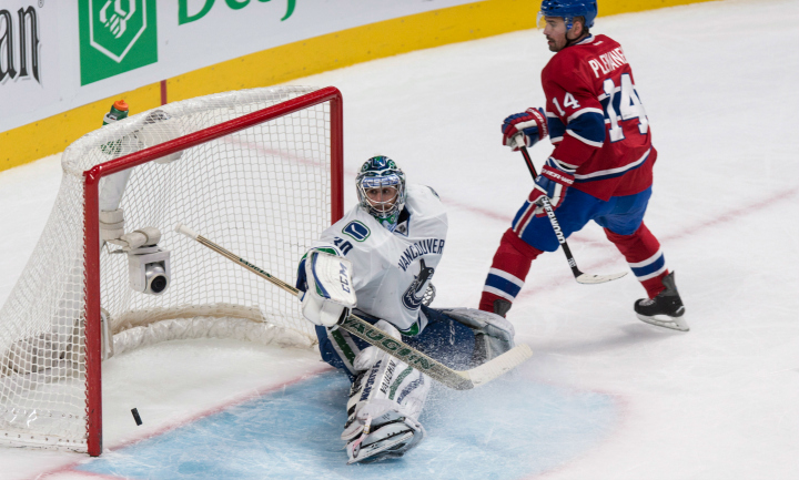 Montreal Canadiens' Tomas Plekanec scores past Vancouver Canucks goalie Ryan Miller during third period NHL hockey action Tuesday, December 9, 2014 in Montreal. The Canadiens beat the Canucks 3-1.