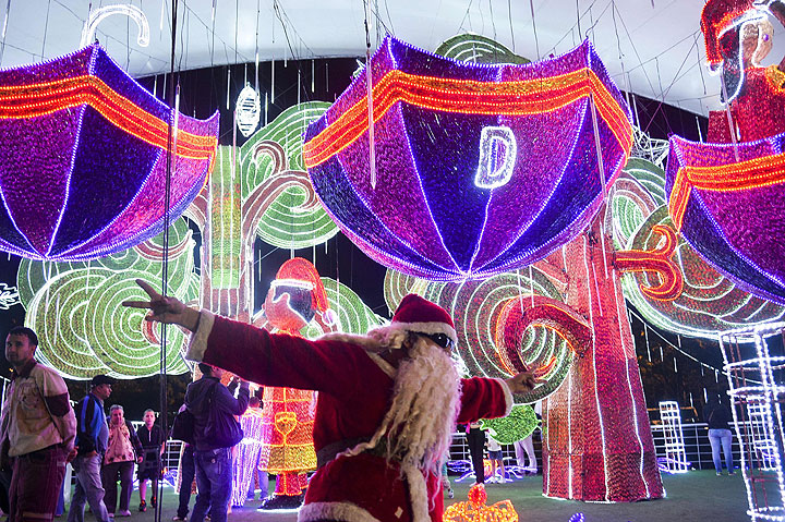 A man dressed as Santa Claus gestures next to the Christmas lights on December 9, 2014 in Medellin, Antioquia department, Colombia.