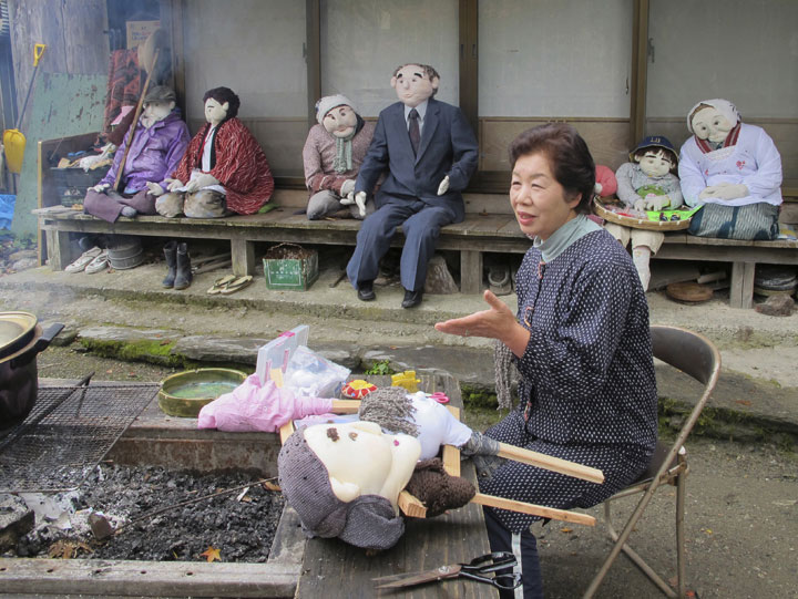 In this Thursday, Nov. 6, 2014 photo, Tsukimi Ayano speaks as she stitches a scarecrow  at her home in the mountainous village of Nagoro, Tokushima Prefecture, southern Japan.                   