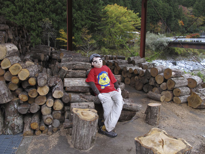 In this Thursday, Nov. 6, 2014 photo, a scarecrow sits on a log pile in Nagoro, Tokushima Prefecture, southern Japan.