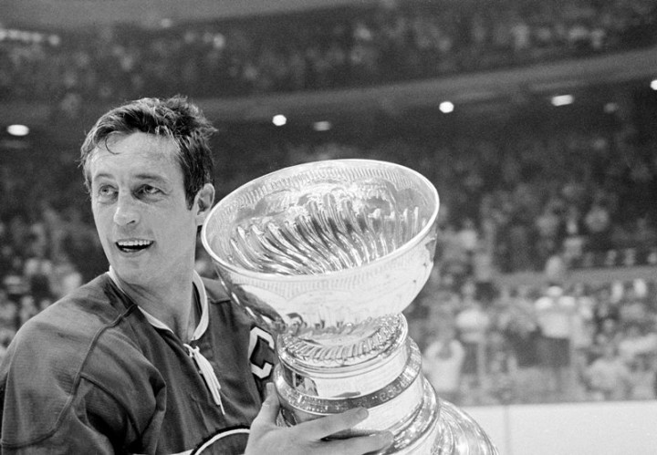 Montreal Canadiens team captain Jean Beliveau holds the Stanley Cup trophy after his team's 3-2 victory over the Chicago Black Hawks in the NHL playoff game in Chicago, Ill., Tuesday night, May 18, 1971.