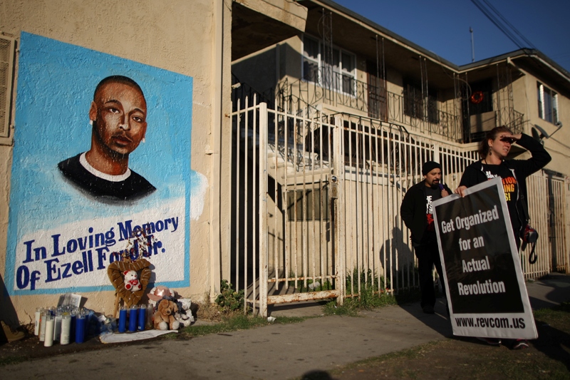 Activists look at a mural of Ezell Ford, a 25-year-old mentally ill black man, at the site where he was shot and killed by two LAPD officers in August, on December 29, 2014 in Los Angeles, California. 