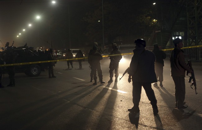 Afghanistan's security forces walk around the French Cultural Center, which was targeted by a suicide attacker in Kabul, Afghanistan on Thursday, Dec. 11, 2014.