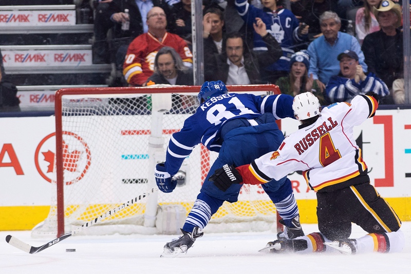 Toronto Maple Leafs forward Phil Kessel (81) fights off Calgary Flames defenceman Kris Russell (4) to score a empty net goal during third period NHL hockey action in Toronto on Tuesday, December 9, 2014. 