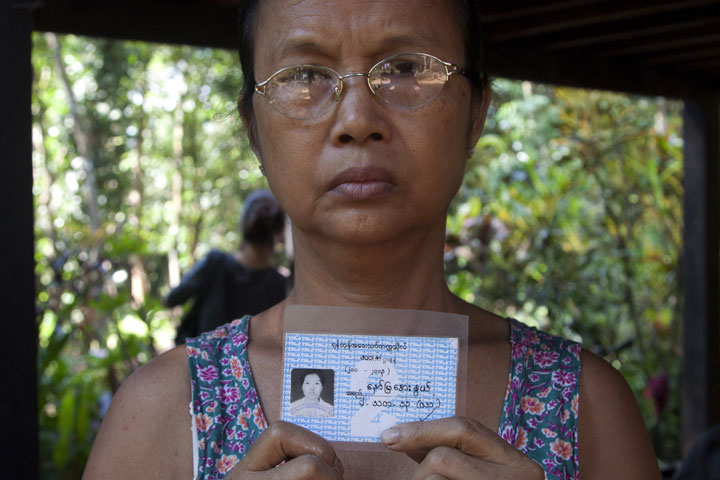 In this photo taken on Nov. 16, 2014, Aye Pu, mother of May Aye Nwe, 20, who was lost at sea during the Indian Ocean tsunami in 2004, holds up her daughter's student identification card during an interview at her home in Seint Paing, Myanmar. 
