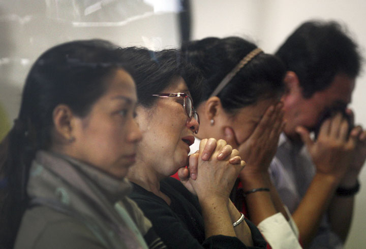 Relatives of passengers on the AirAsia flight QZ8501 wait for the latest news on the search of the missing jetliner at Juanda International Airport in Surabaya, East Java, Indonesia, Monday, Dec. 29, 2014.