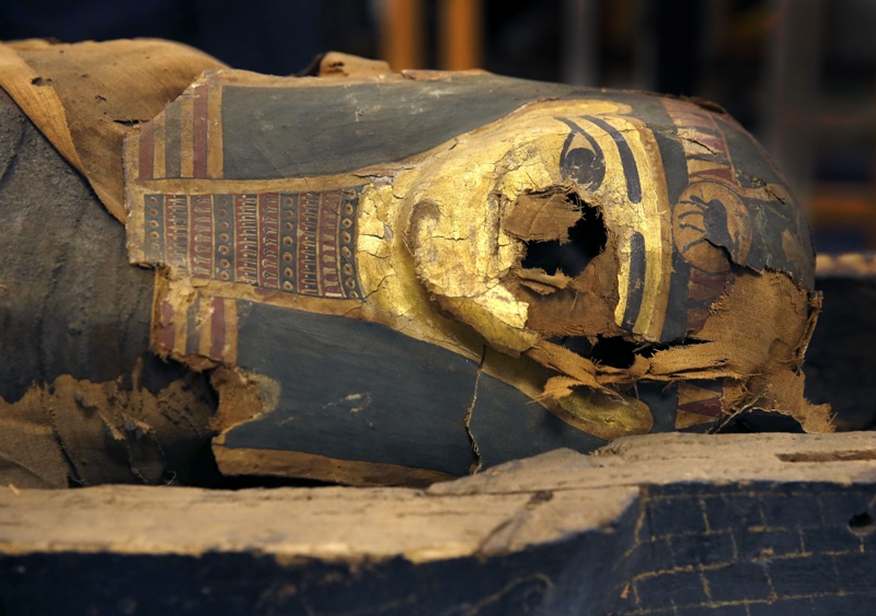 In this photo taken Friday, Dec. 5, 2014, in Chicago, the mummified body of Minirdis, a 14-year-old Egyptian boy and his burial mask lie in his opened coffin.