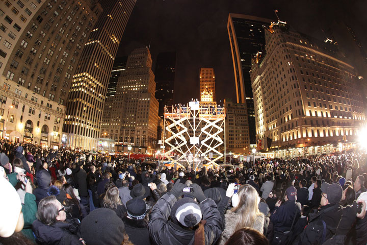 In this Nov. 2013 file photo released by the Jewish News Agency, people gather around the world’s largest Hanukkah menorah on Fifth Avenue and 59th Street near Central Park in New York. This year’s menorah will be lit nightly Dec. 16-23 in the same location. The menorah is 32 feet high.