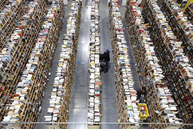 Amazon.com employees work the shelves along the miles of aisles at an Amazon.com Fulfillment Center in Phoenix.