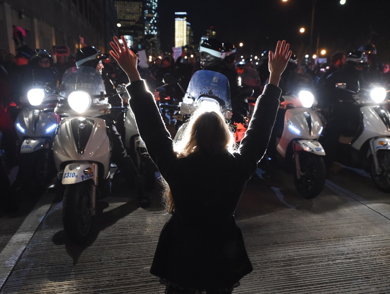 A protestor hold up her hands in front of the NYPD as she and others block traffic on the West Side Highway during demonstrations December 4, 2014 in New York City.