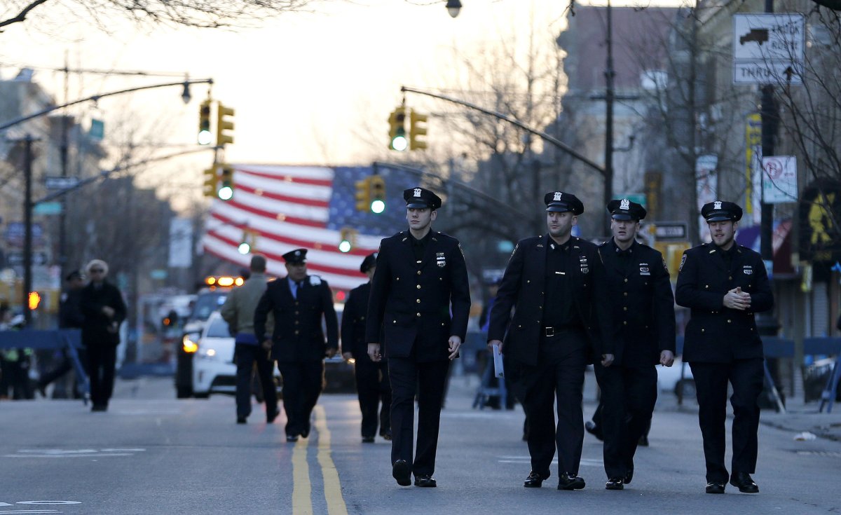New York City police officers walk toward funeral services for officer Rafael Ramos in Queens, New York on Saturday, Dec. 27, 2014.